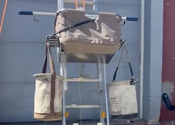 CarryALL loaded with a duffel and two tool buckets, hanging from the ladder
